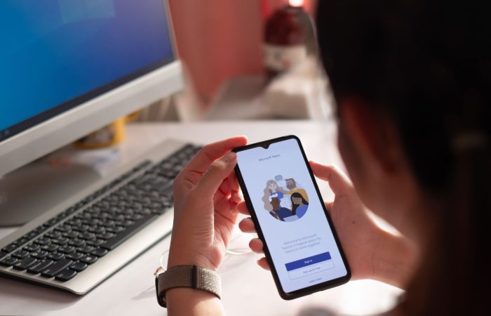 Woman holding a phone with Microsoft Teams starting